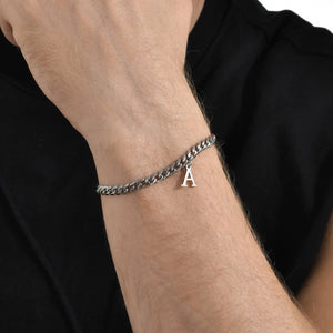 Close-up of a silver Cuban link initial bracelet with the letter A on the wrist