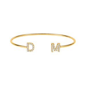 Gold dainty double initial cuff bracelet with the letters D and M in sparkling stones