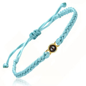 Light blue braided adjustable cord bracelet with a gold photo projection stone