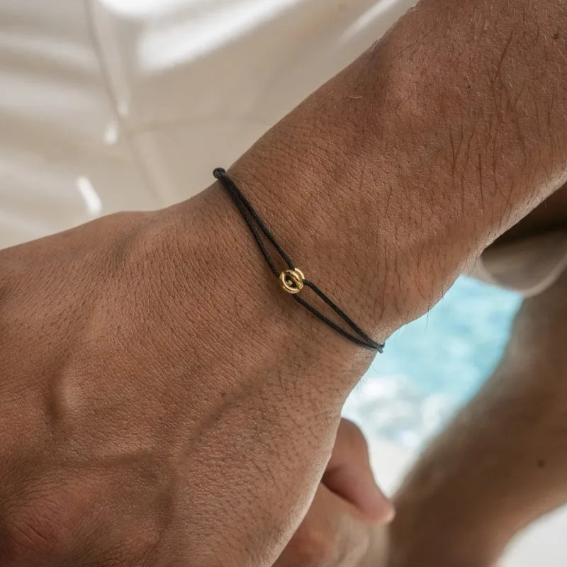 Black Cord Infinity Bracelet with Gold Ring on Wrist