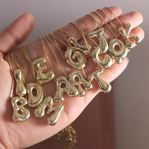 Bold Bubble Initial Pendant Necklace Gold multiple letter variants displayed on hand