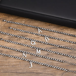 Silver Cuban link initial bracelets with letters A, B, Q, M, N and J on wood
