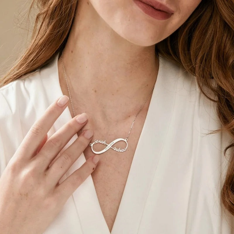 Silver infinite love necklace with engraved names worn with a white robe