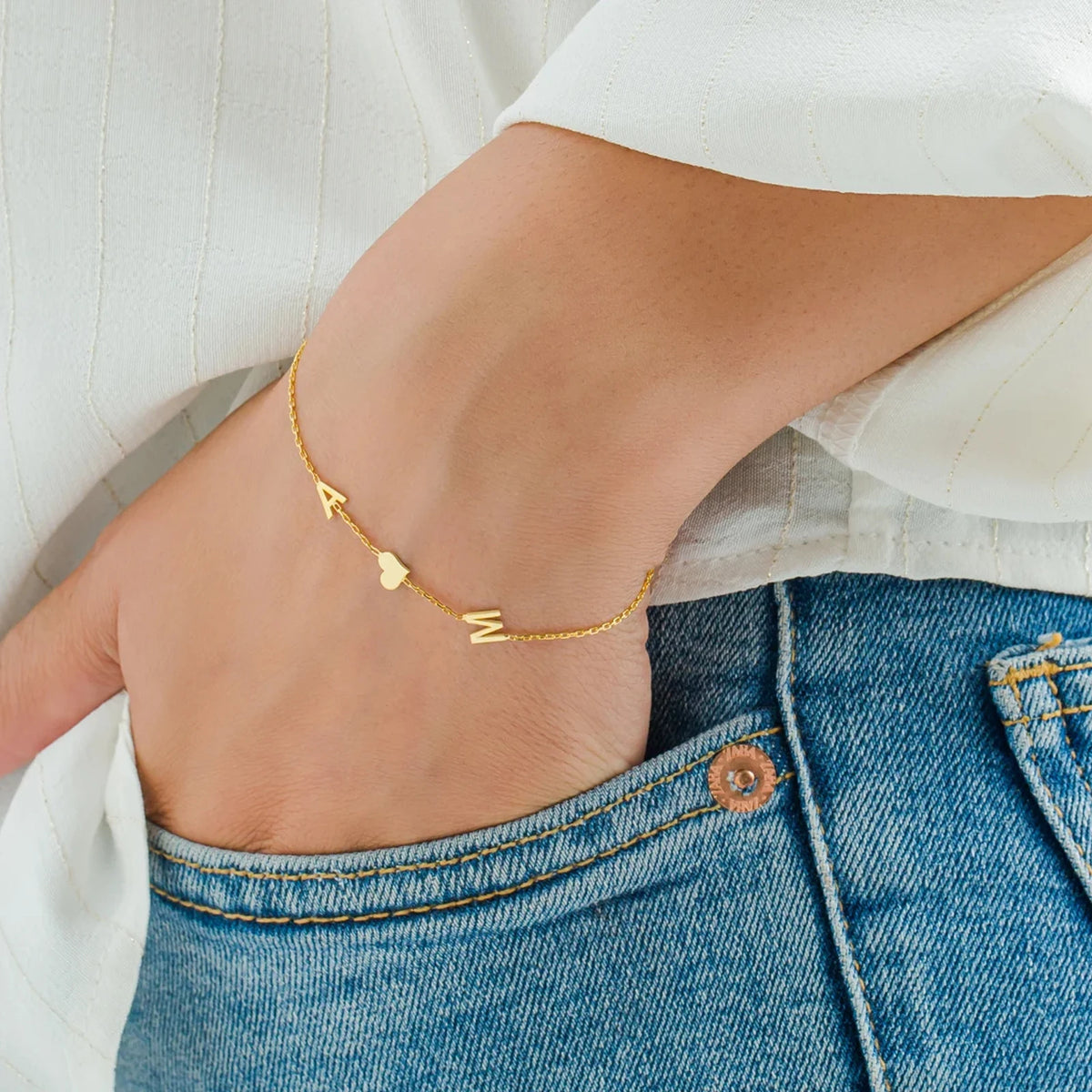 Gold multiple initials bracelet A and M with heart worn on the wrist