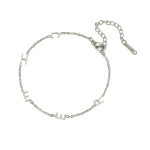 Silver multiple initials bracelet with five letters and an extender chain lying flat
