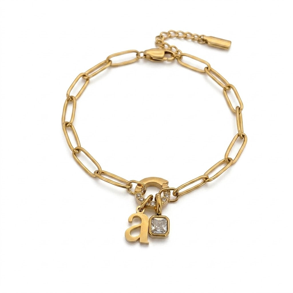 Gold paperclip birthstone initial bracelet with the letter a and a clear square stone