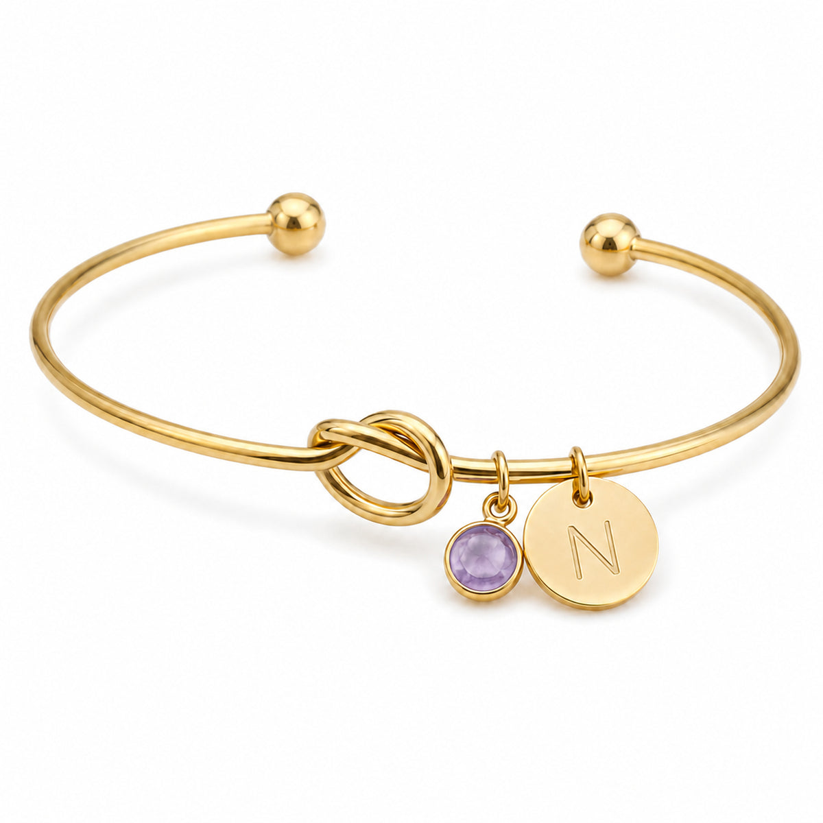 Gold tied love knot bangle with the initial N and a purple birthstone
