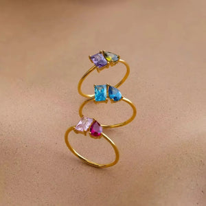 Three gold double birthstone rings with purple, blue and pink stones